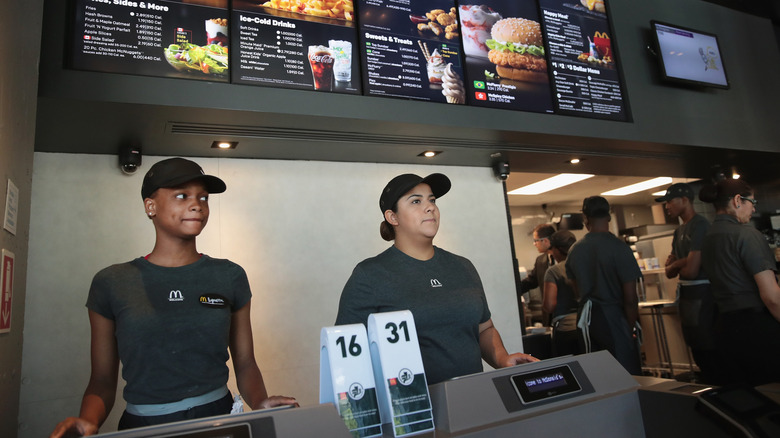 McDonald's employees stand behind a restaurant counter