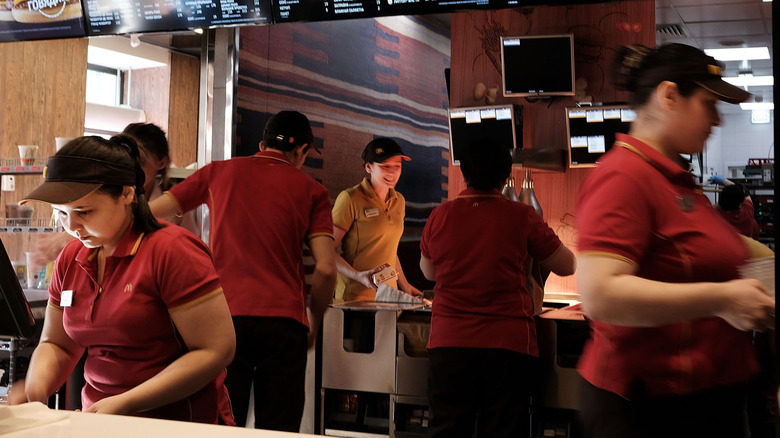 A group of McDonald's workers in a busy restaurant