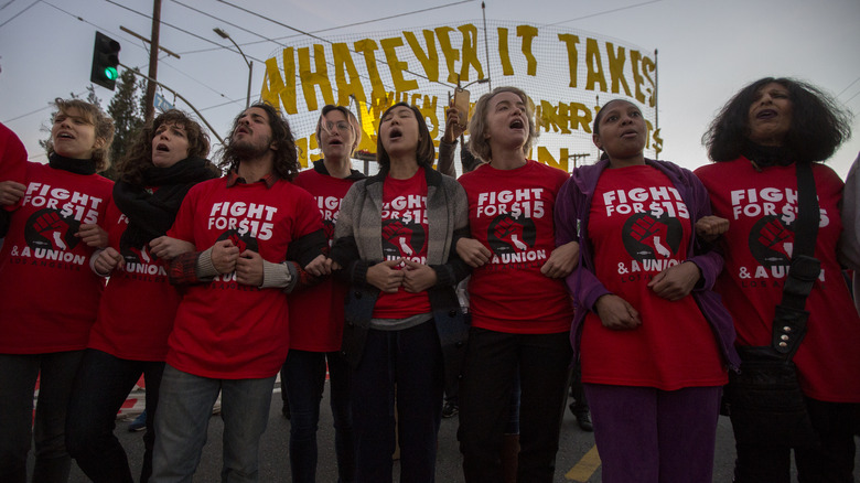 A group of workers lock arms during a Fight for $15 protest