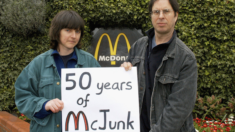 David Morris and Helen Steel, two Greenpeace activists who entered into a lengthy legal battle with McDonald's, hold a sign saying "50 Years of McJunk"