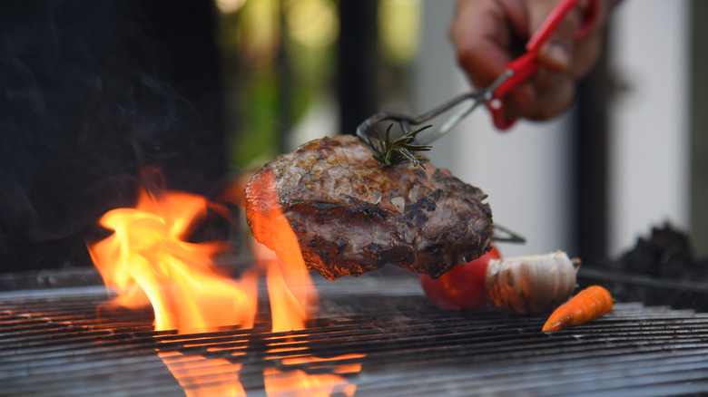 Grilling steak over an open flame