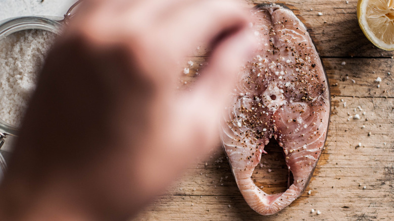 Salting a piece of fish