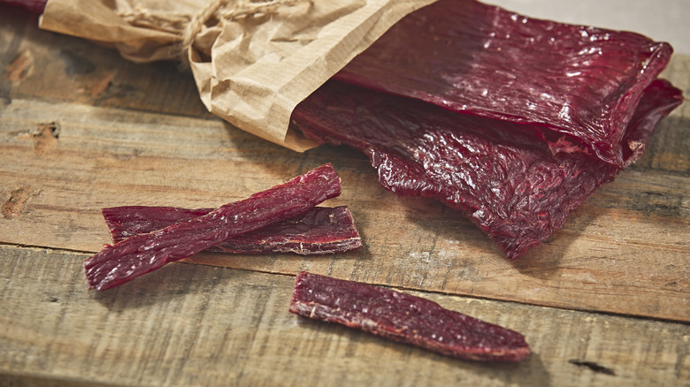 Open bag of beef jerky with a few pieces astray