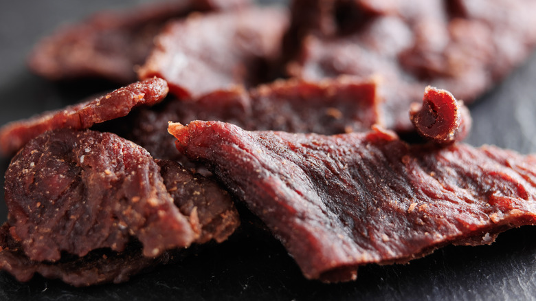 Pieces of beef jerky on a black wooden table