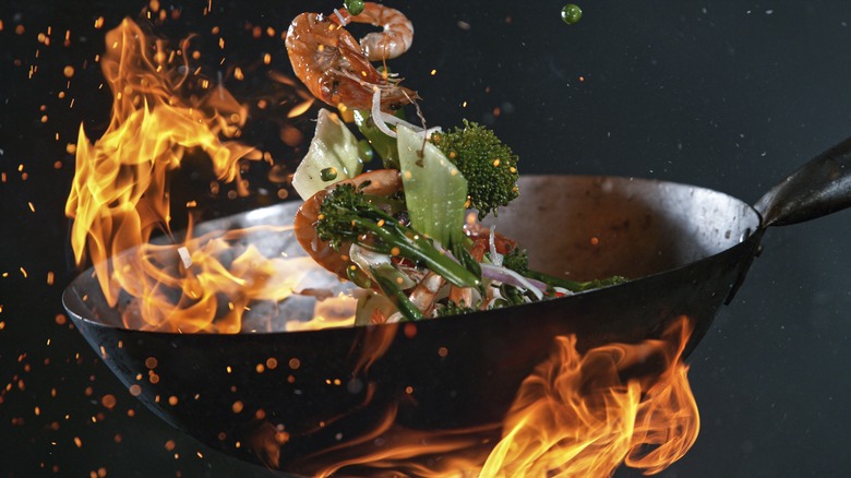 tossing veggies and shrimp in wok