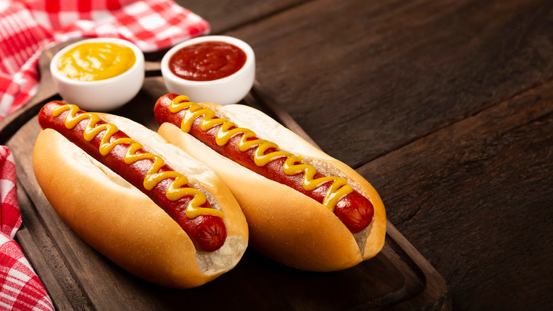 two hot dogs with condiments