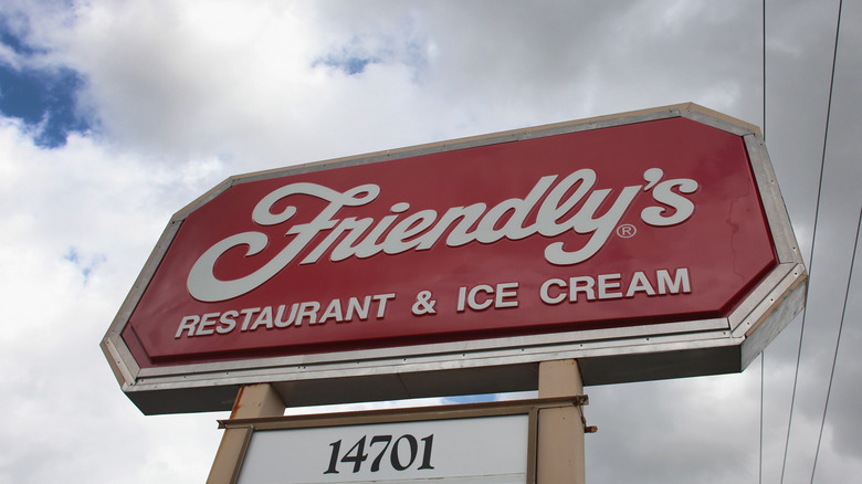 Looking up at a Friendly's standalone sign, with dark clouds in the background