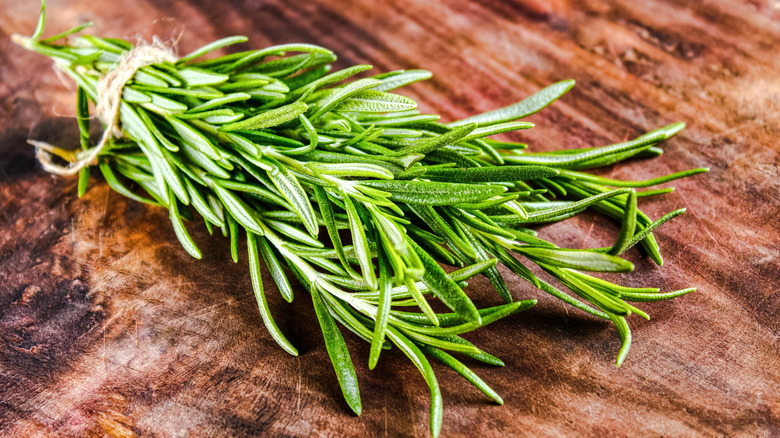 Bunch of fresh rosemary tied together with twine on a wooden countertop