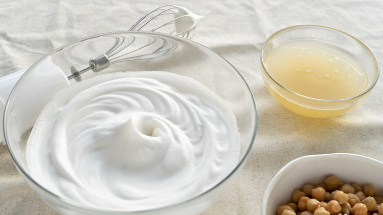 whipped aquafaba with a bowl of chickpeas and liquid
