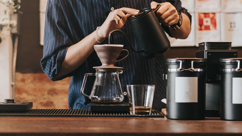 barista pouring water over coffee
