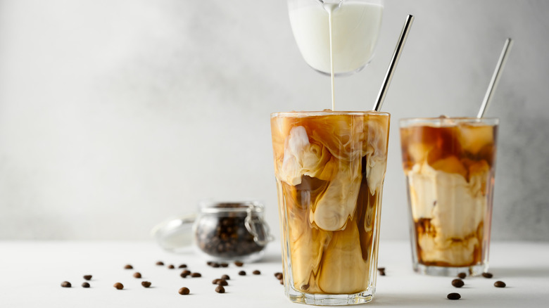 milk being poured into coffee beverage