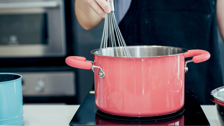 Person mixing food in pot