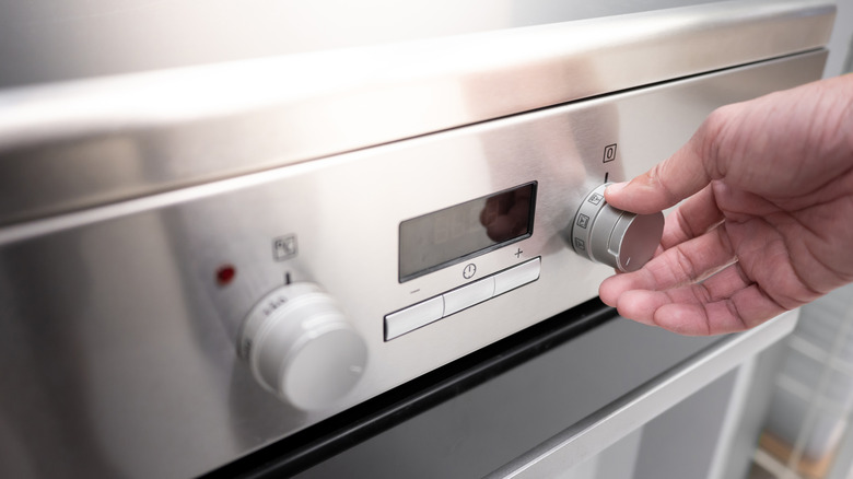 Person turning oven temperature knob