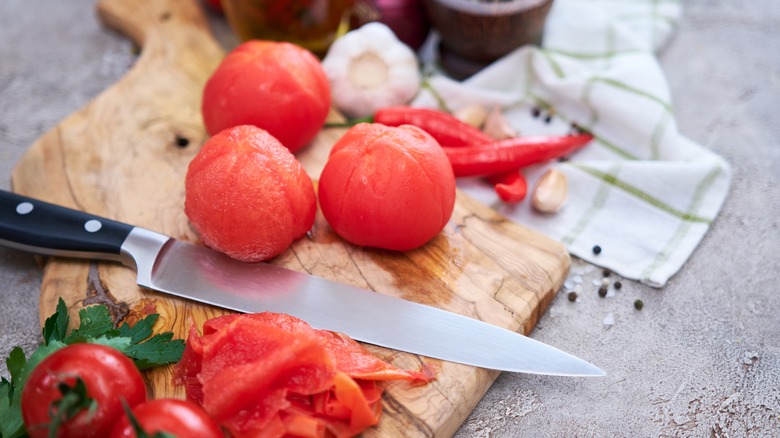 Blanched tomatoes with paring knife