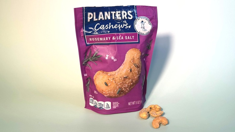 Planters rosemary and sea salt cashews bag with some cashews next to the closed bag