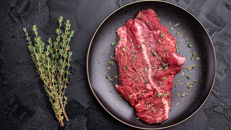 Raw hanger tender beef steak with herbs.