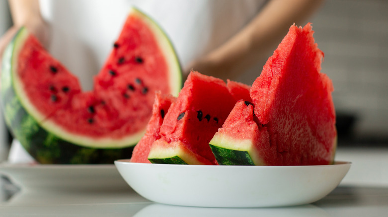 Cut watermelon sitting on countertop in bowls