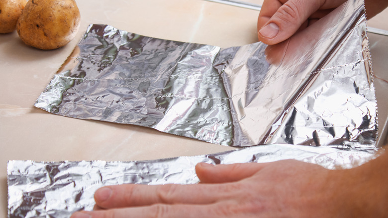 Man tears aluminum foil 