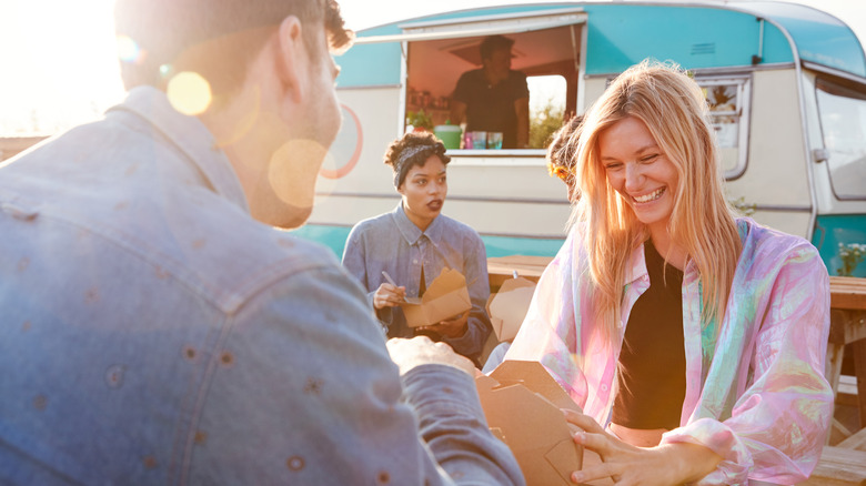 people eating in front of food truck