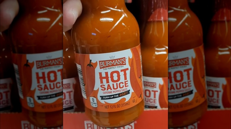 Hand pulling Burman's Hot Sauce from the shelf at Aldi