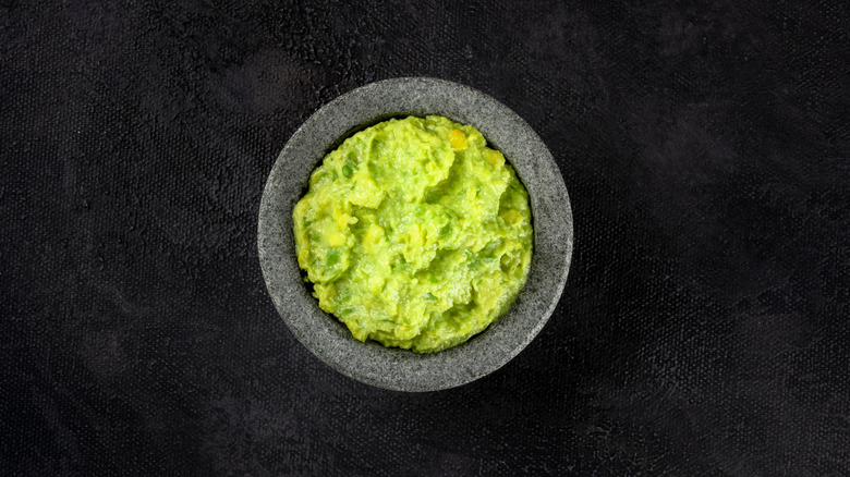 Guacamole in moratar, black background