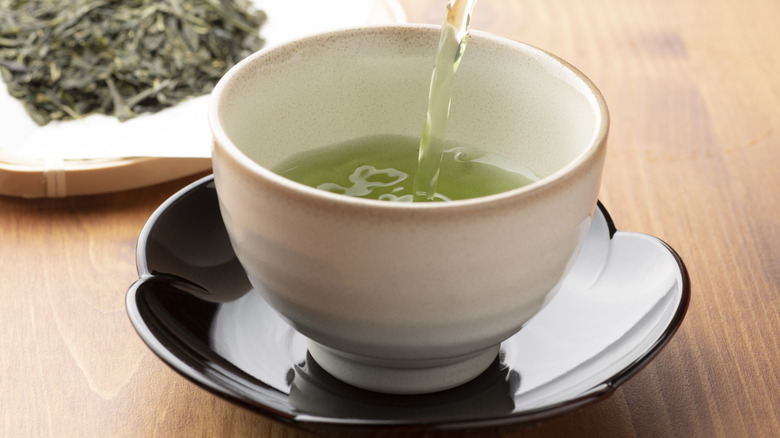 green tea being poured into cup