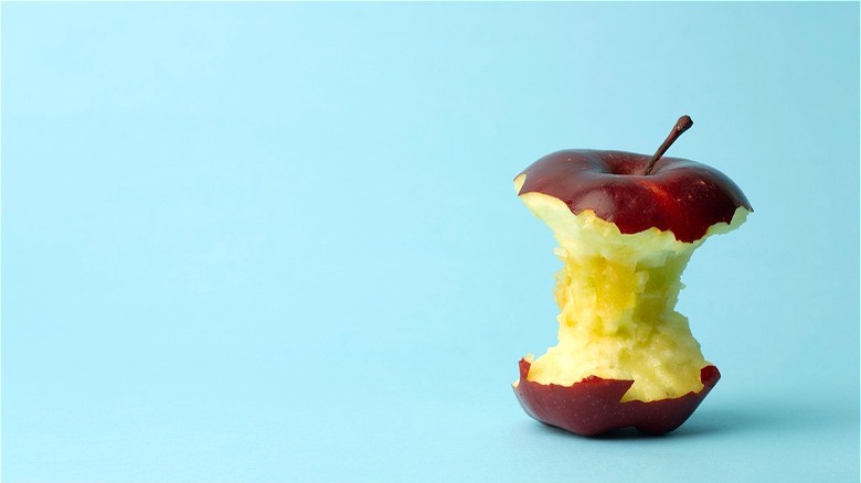 Red-skinned apple core on blue back drop