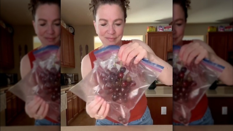 Putting stem of grapes in bag 