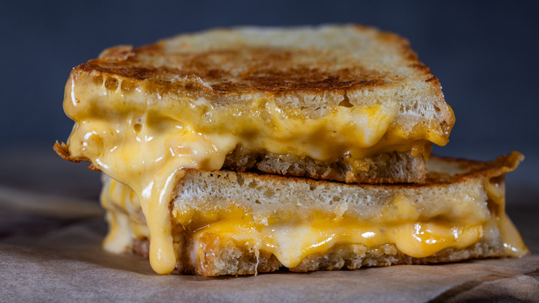 Sliced grilled cheese sandwich on baking paper