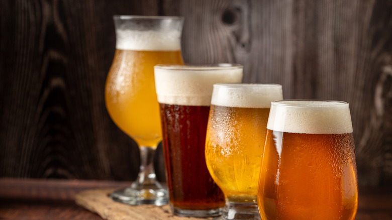 Four glasses of various beers on wooden bar