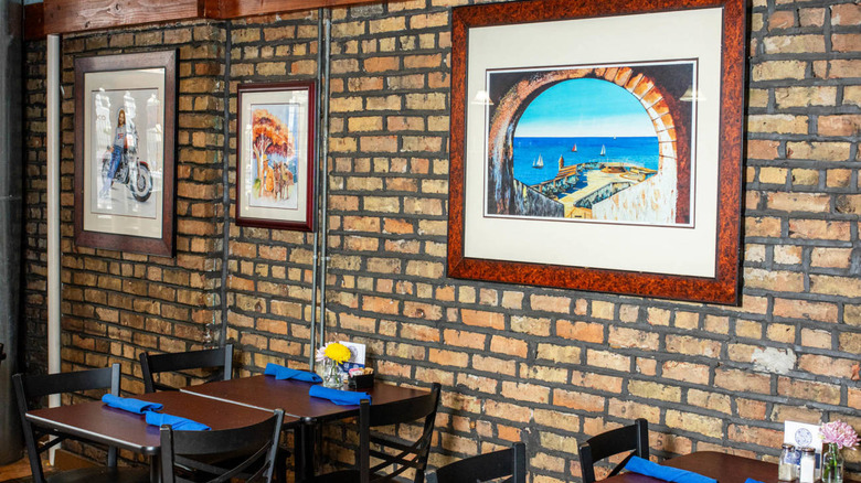 brick wall with artwork hanging and tables