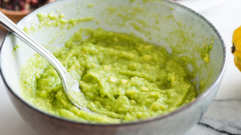 mashing avocado with fork