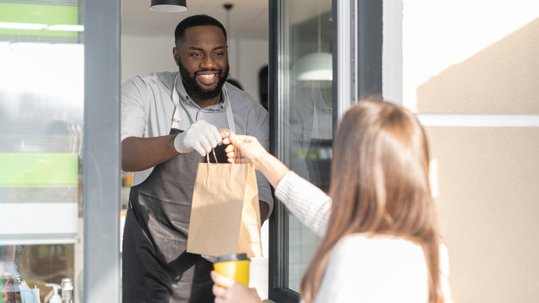 Fast food employee smiling through window