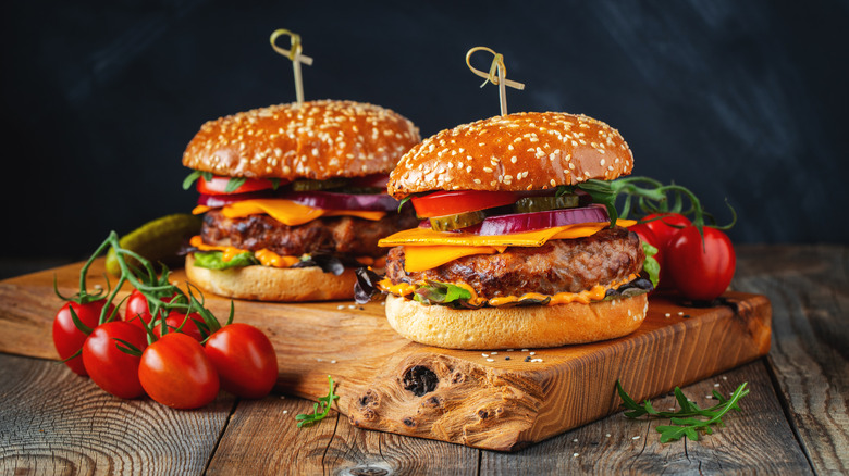 Two burgers on a board