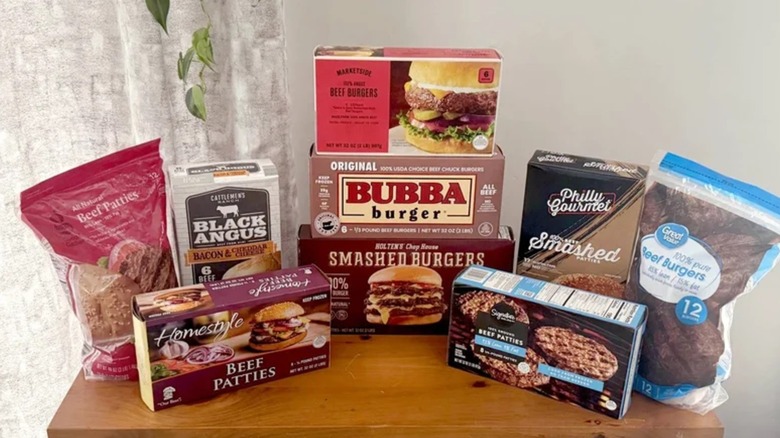 Different brands of frozen beef burgers arranged on a table