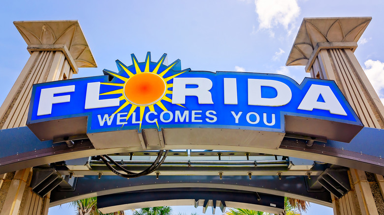 A bright blue sign that says Florida welcomes you against a bright blue sky