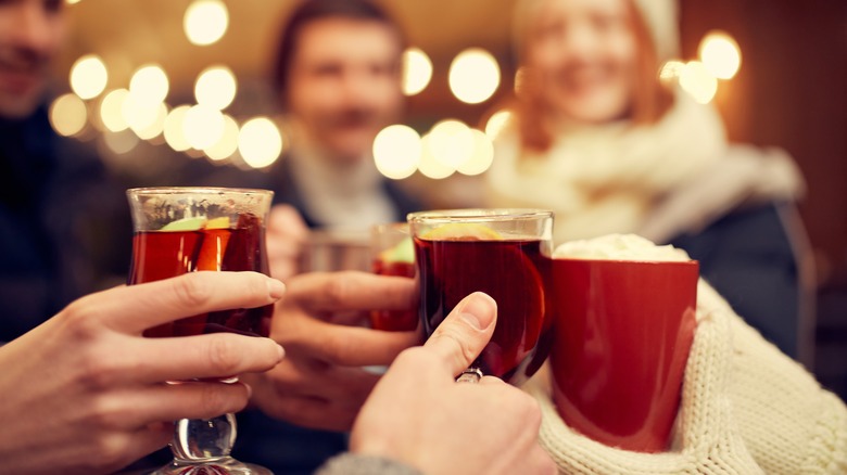 People toasting with hot drinks.