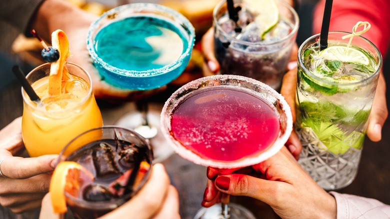 people toasting with different cocktails