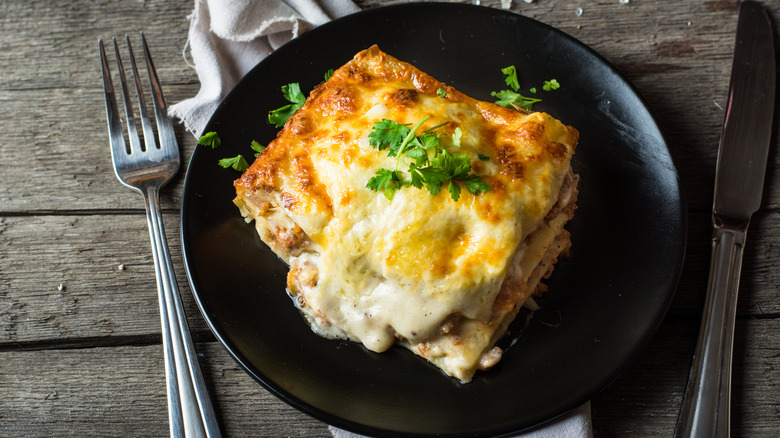 White lasagna on black plate