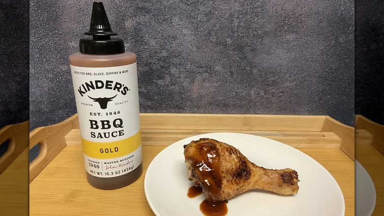 Kinder's Gold barbecue sauce next to chicken leg