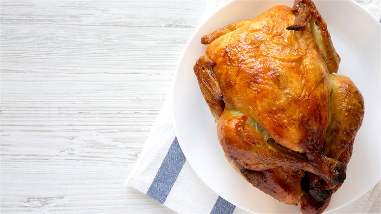 Rotisserie chicken on white plate 