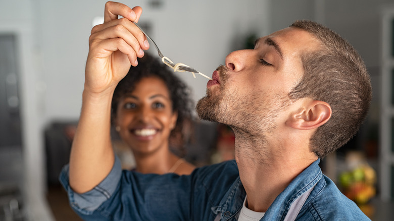 Man tasting pasta for doneness