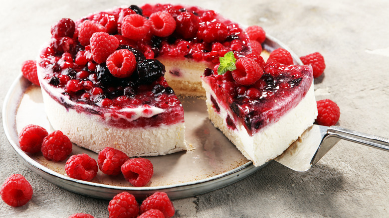 A raspberry cheesecake being plated