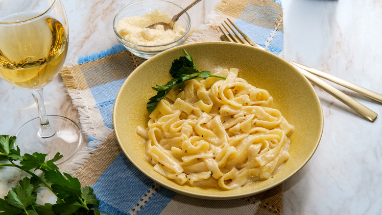 Creamy pasta dish with glass of wine