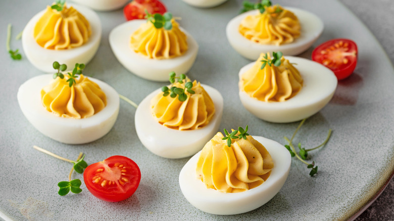 Tray of deviled eggs garnished with microgreens.