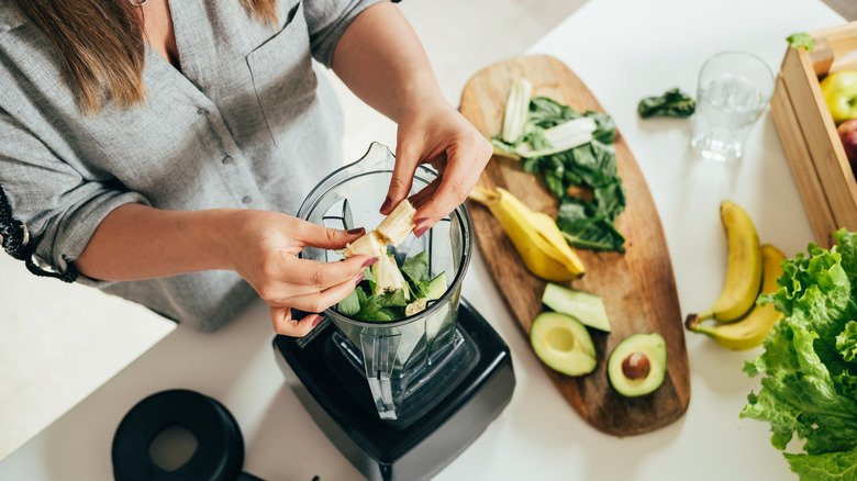 Adding healthy smoothie ingredients to blender