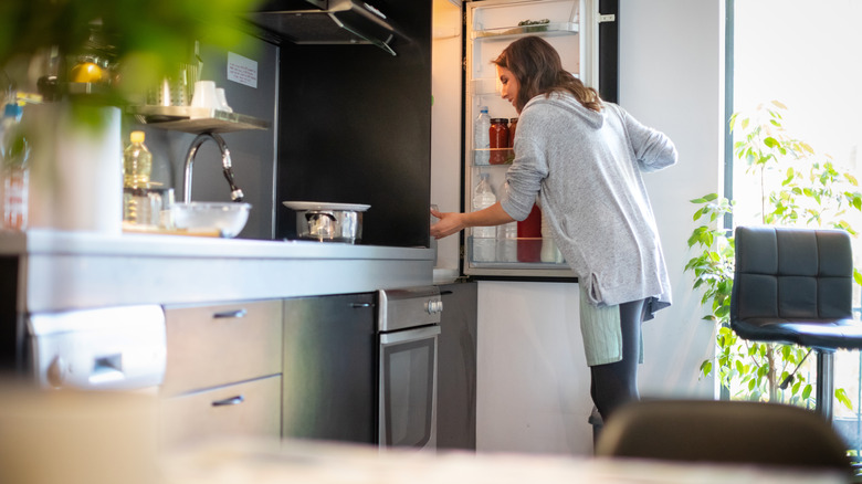 Person taking food from refrigerator