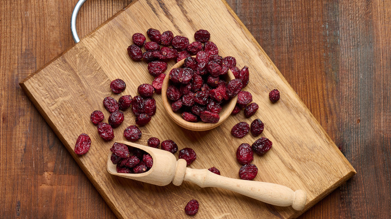 dried cranberries scattered on a wood cutting board