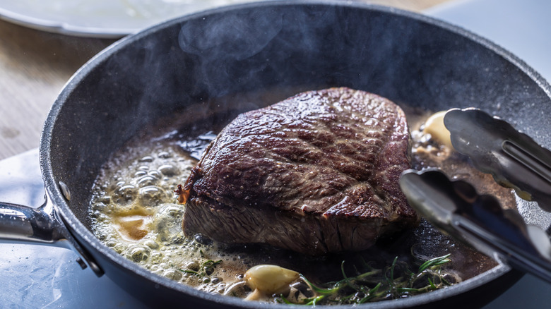 Steak cooking in a pan