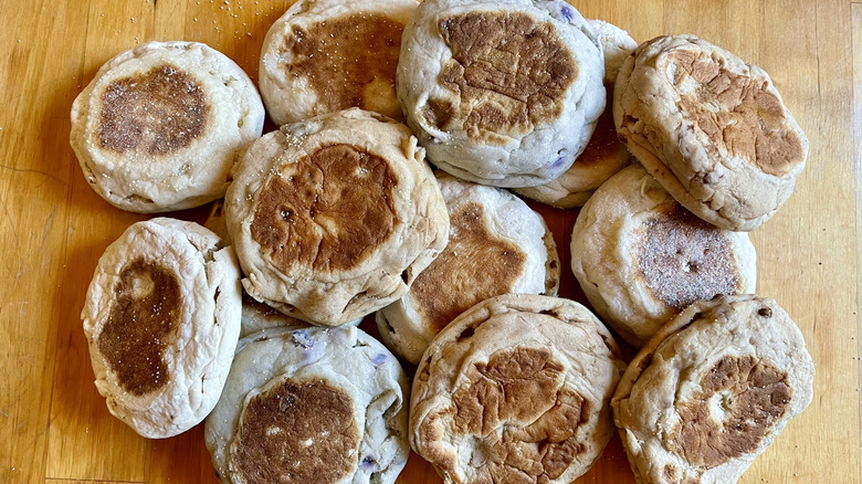 A pile of Thomas' English muffins of different flavors on a wooden table